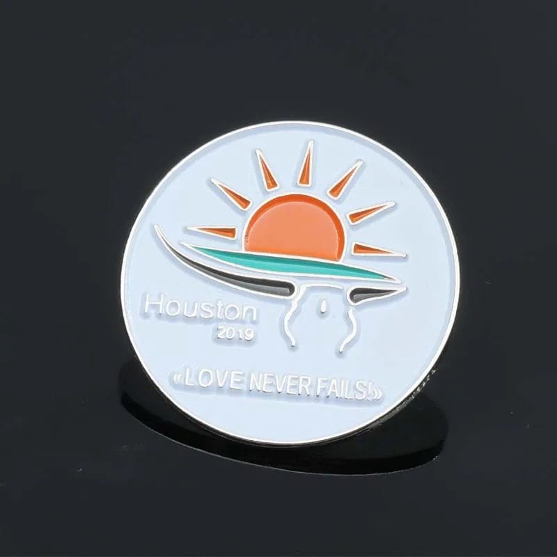 Un pin con la frase "Houston Love Never Fails" (El amor de Houston nunca falla), que simboliza la resistencia y el afecto de la comunidad de Houston.