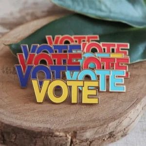Una colección de insignias de voto personalizadas con la palabra "vote" en un lugar destacado de cada insignia.