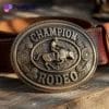 مشبك حزام نحاسي يحمل عبارة "Champion Rodeo" (بطل الروديو) بتصميم كلاسيكي لمسابقة رعاة البقر.