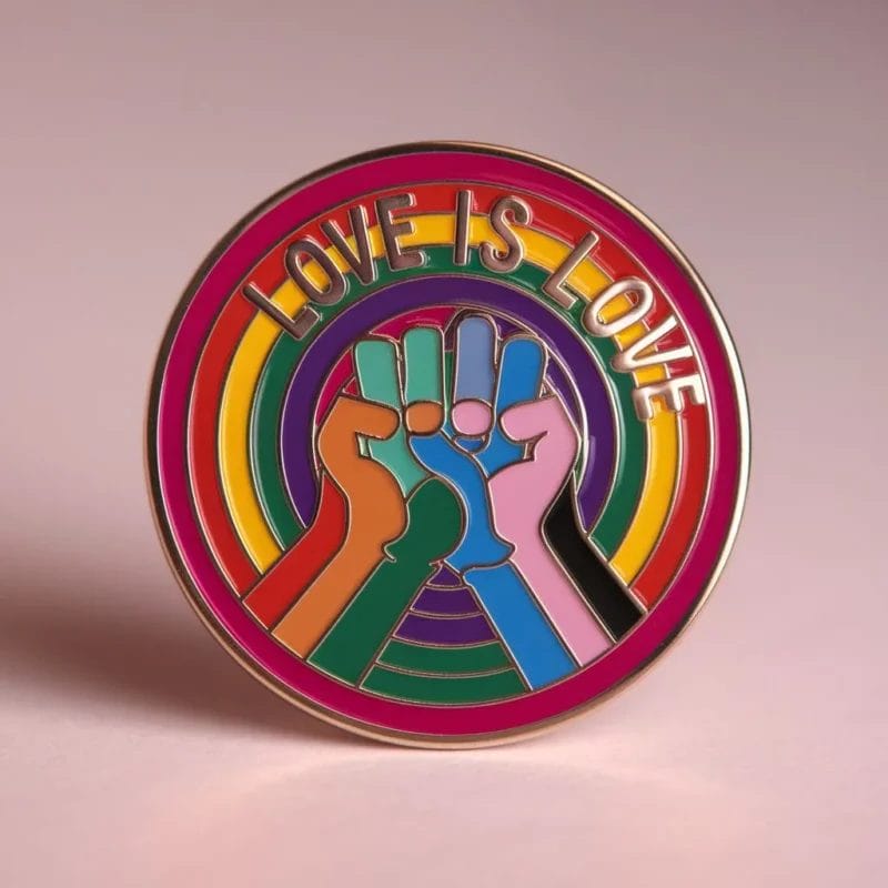 Colorful enamel pin with "Love is Love" text, representing LGBT pride and support for the community.