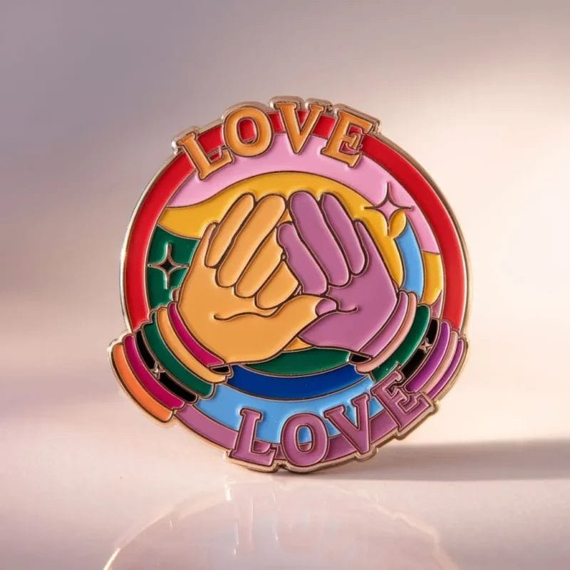 Vibrant enamel pin displaying "love love love," representing LGBT pride and the celebration of love in all forms.
