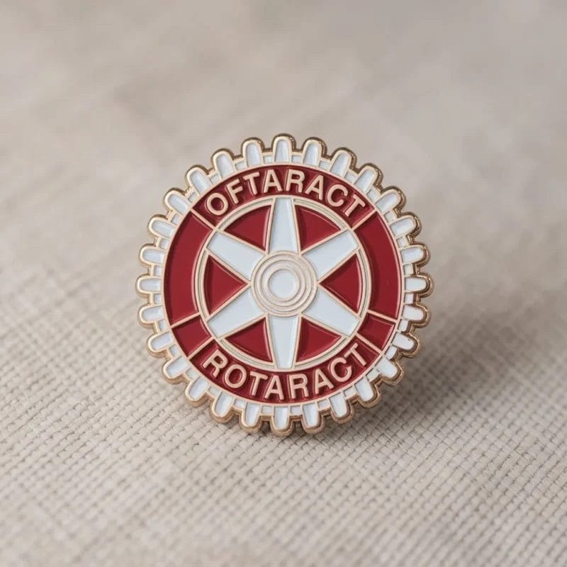 Una spilla Rotaract rossa e bianca con la parola "Rotary" in evidenza.