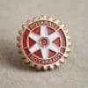 Una spilla Rotaract con la scritta "Rotary Club", che simboleggia la dedizione all'azione comunitaria e alla leadership.