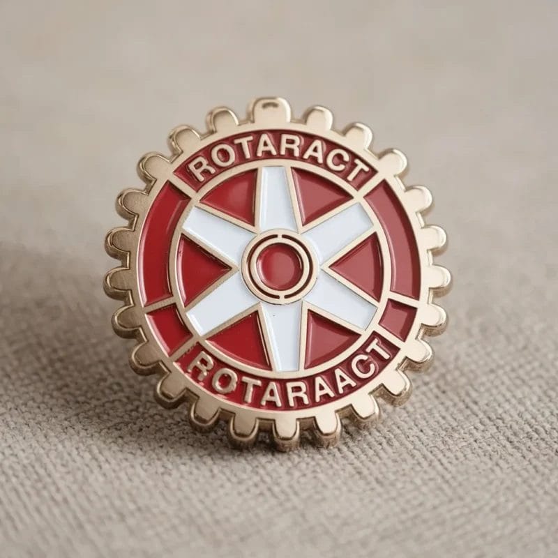 Una spilla Rotaract con la scritta "Rotary Club", che simboleggia la dedizione all'azione comunitaria e alla leadership.
