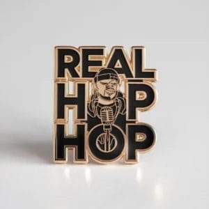 Una spilla con la frase "Real Hip Hop" a caratteri cubitali, che rappresenta la cultura e lo stile hip hop.