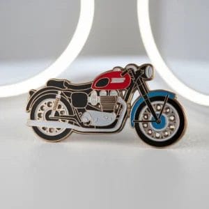 Una spilla da motociclista visualizzata su sfondo bianco, che mette in mostra il suo design dettagliato e i suoi colori vivaci.