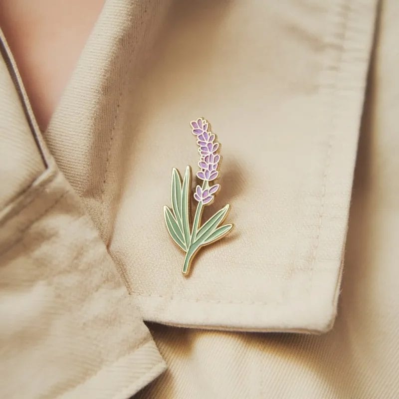 Una spilla color lavanda con un delicato disegno di fiori viola, perfetta per aggiungere un tocco di eleganza a qualsiasi abbigliamento.