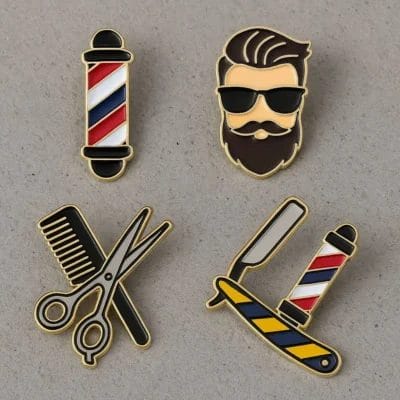 床屋の道具やシンボルをモチーフにしたカラフルなエナメル・ピンのセット。